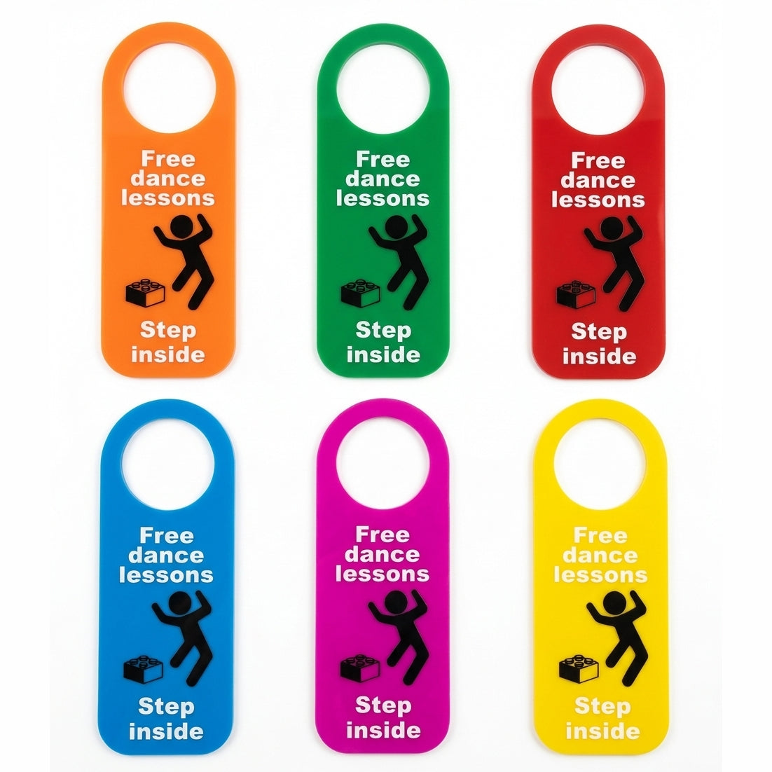 Six colorful rectangular hanger tags with rounded corners, each in a different bright color: orange, green, red, blue, pink, and yellow. Each tag has a circular cutout at the top, white text reading 'Free dance lessons' and 'Step inside,' plus a black stick-figure dancing and a small dance lesson icon.