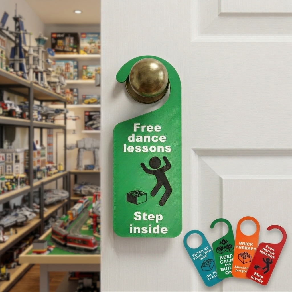 A green novelty door hanger sign with a brass doorknob attachment, hanging on a white door. The sign reads 'Free dance lessons' with a stick figure dancing around a Lego brick and 'Step inside' text.